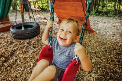 little boy playing on Outdoor Swing and Slide Set